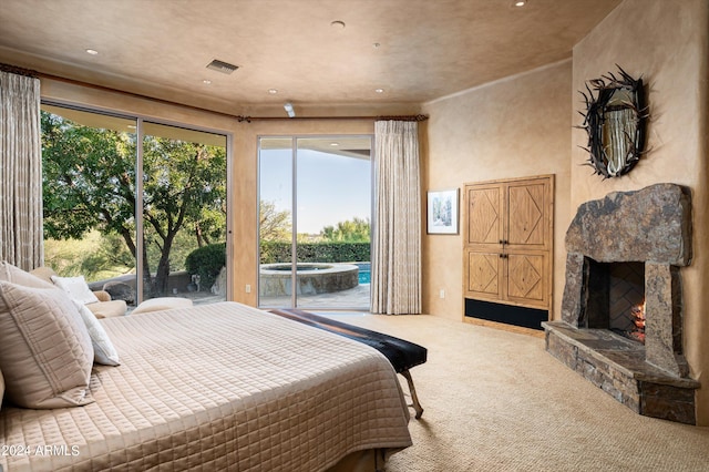 bedroom featuring carpet flooring, a fireplace, and access to outside