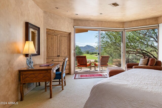 bedroom with access to outside, a mountain view, and carpet flooring