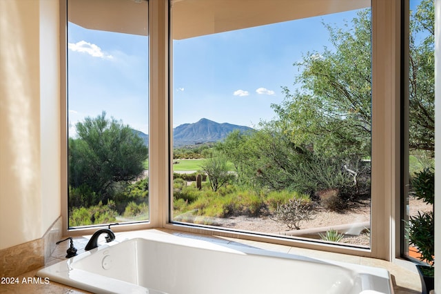 bathroom featuring a mountain view and a relaxing tiled tub