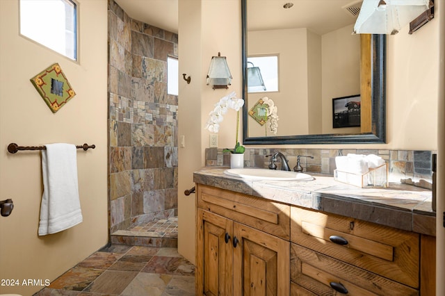 bathroom with walk in shower, backsplash, and vanity