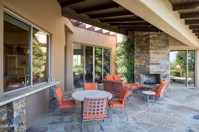 view of patio featuring an outdoor stone fireplace and sink