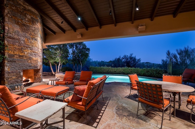 patio at twilight with an outdoor stone fireplace