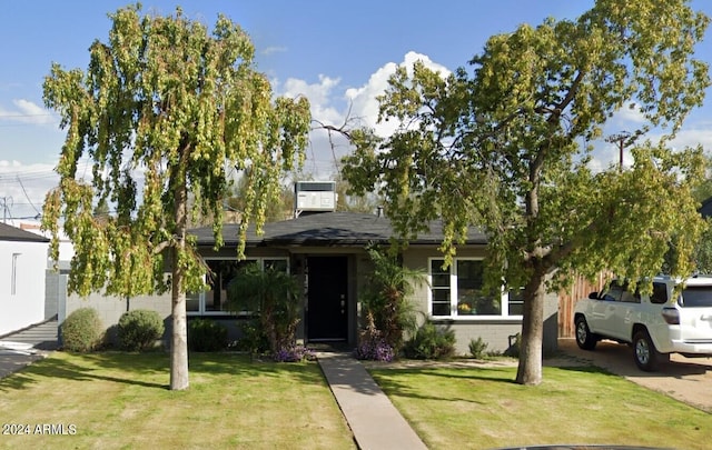 view of front of house featuring central AC and a front lawn