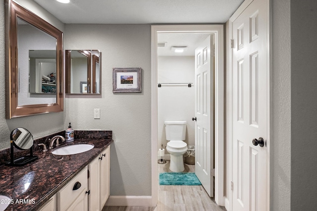 bathroom featuring hardwood / wood-style flooring, vanity, and toilet