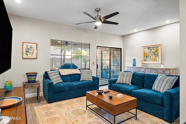 living room with ceiling fan and light hardwood / wood-style flooring