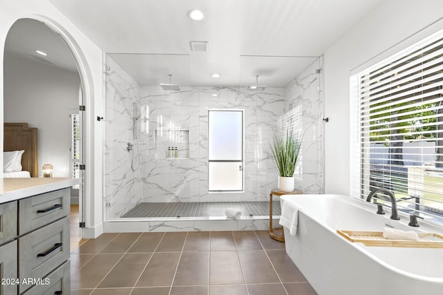 bathroom featuring tile patterned floors, independent shower and bath, and a wealth of natural light