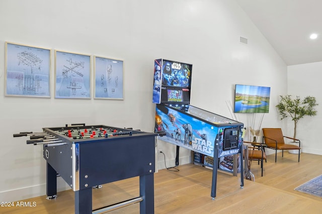 game room featuring hardwood / wood-style floors and high vaulted ceiling