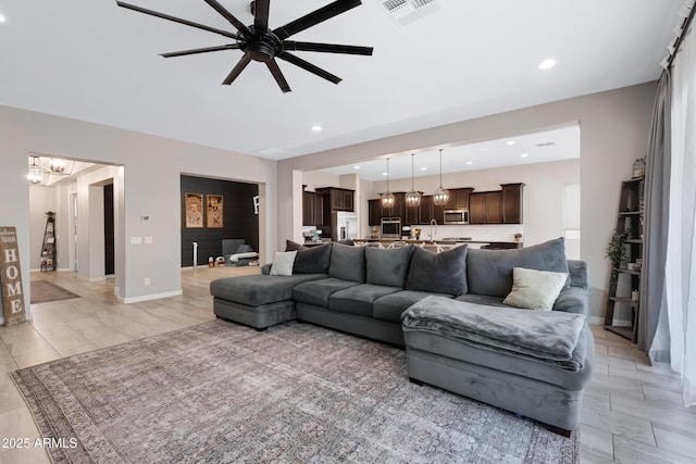 living room with ceiling fan with notable chandelier