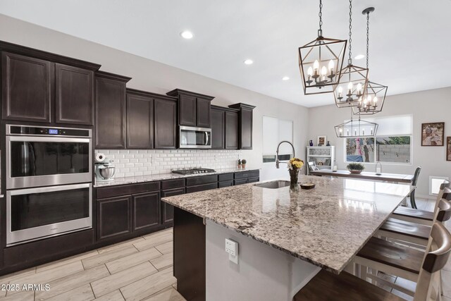 kitchen featuring a spacious island, a breakfast bar, stainless steel appliances, and sink