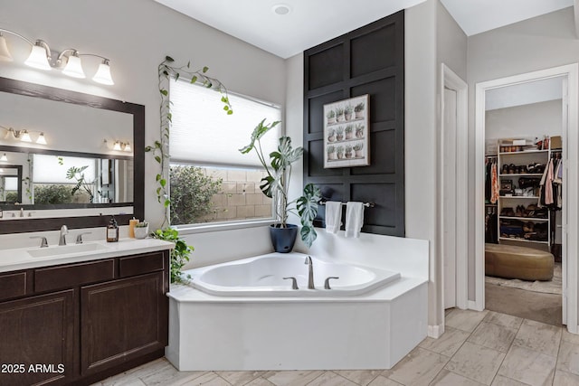 bathroom featuring a washtub and vanity