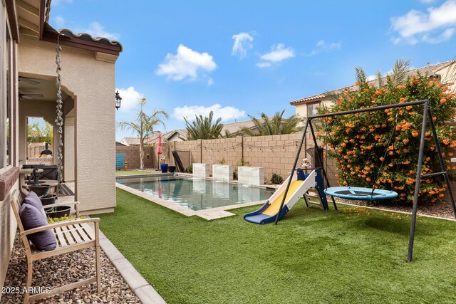 view of playground with a lawn and a fenced in pool