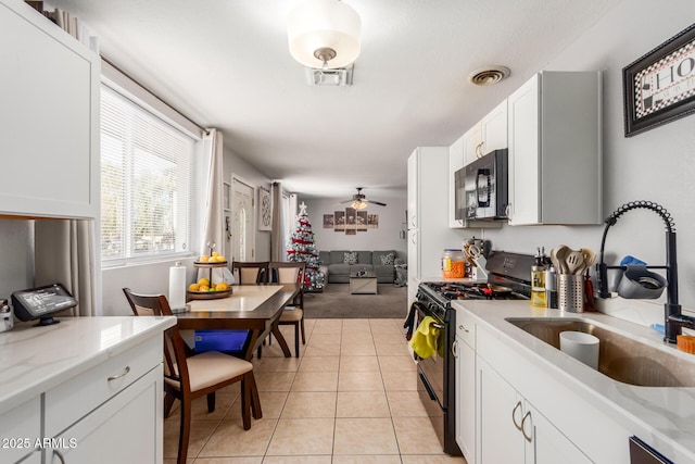 kitchen featuring white cabinetry, light stone countertops, sink, and black appliances