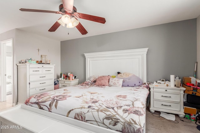 bedroom with connected bathroom, light colored carpet, and ceiling fan