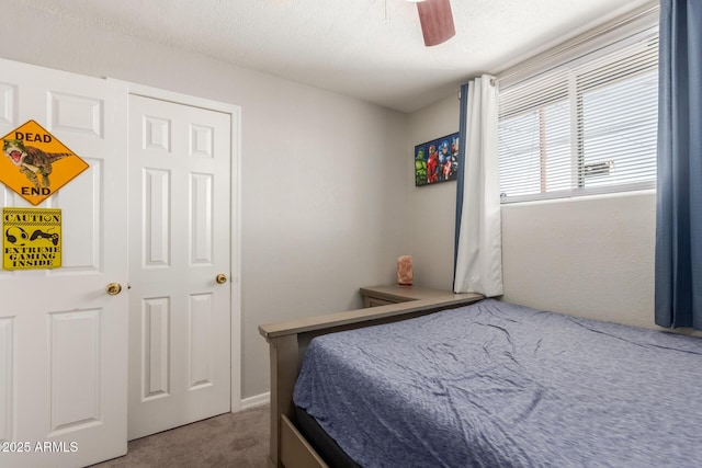 bedroom with ceiling fan, carpet, and a textured ceiling