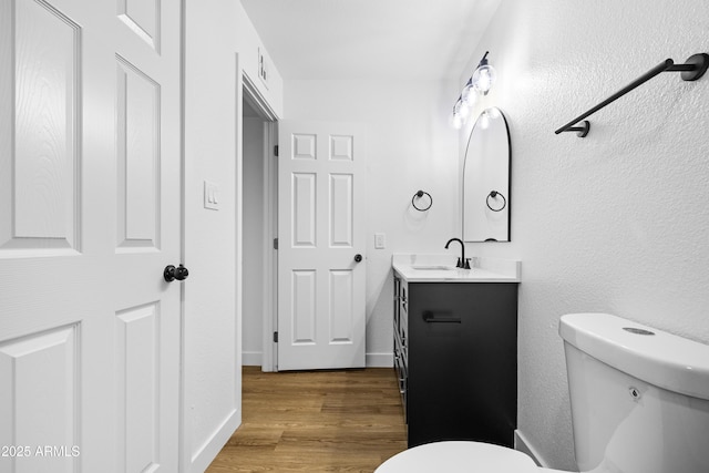 bathroom featuring hardwood / wood-style floors, vanity, and toilet