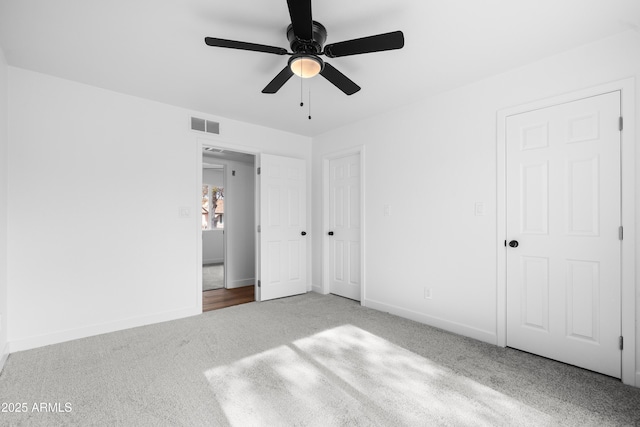 unfurnished bedroom with light colored carpet and ceiling fan