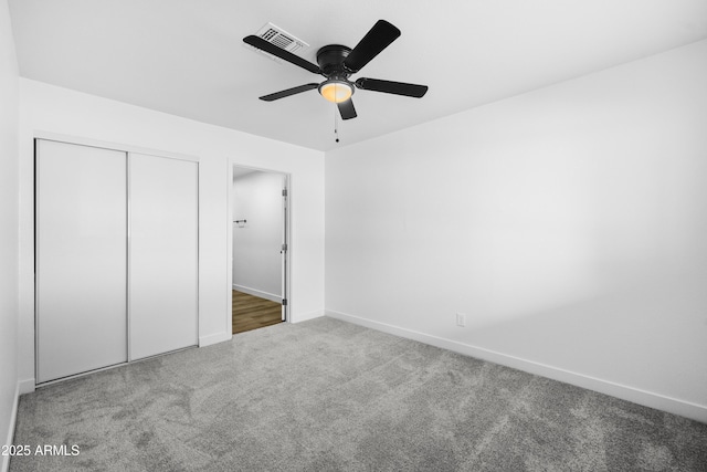 unfurnished bedroom with ceiling fan, a closet, and carpet floors