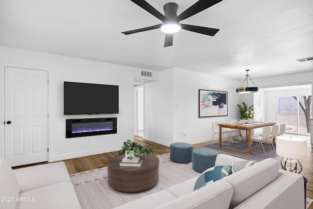 living room featuring ceiling fan and wood-type flooring