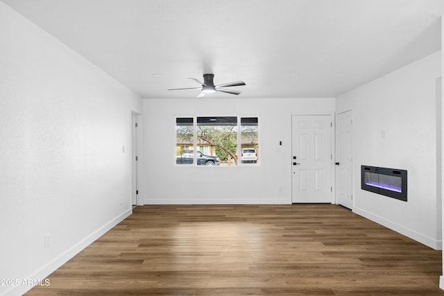 empty room featuring heating unit, ceiling fan, and hardwood / wood-style floors