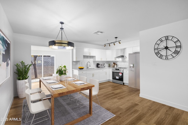 dining area with hardwood / wood-style flooring and sink