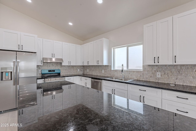 kitchen featuring lofted ceiling, sink, white cabinetry, dark stone countertops, and stainless steel appliances