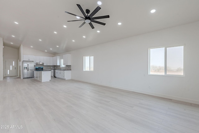 unfurnished living room with lofted ceiling, light hardwood / wood-style flooring, and ceiling fan