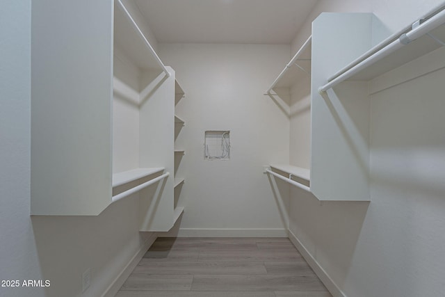 spacious closet with light hardwood / wood-style flooring