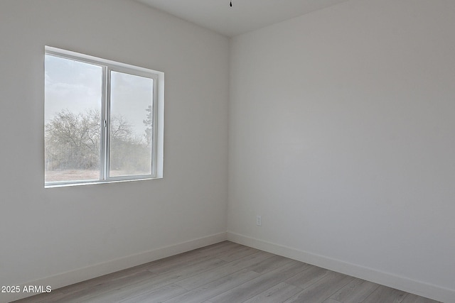 spare room featuring plenty of natural light and light hardwood / wood-style flooring