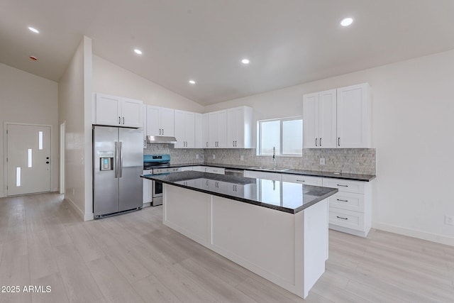 kitchen with sink, white cabinetry, stainless steel appliances, light hardwood / wood-style floors, and a kitchen island