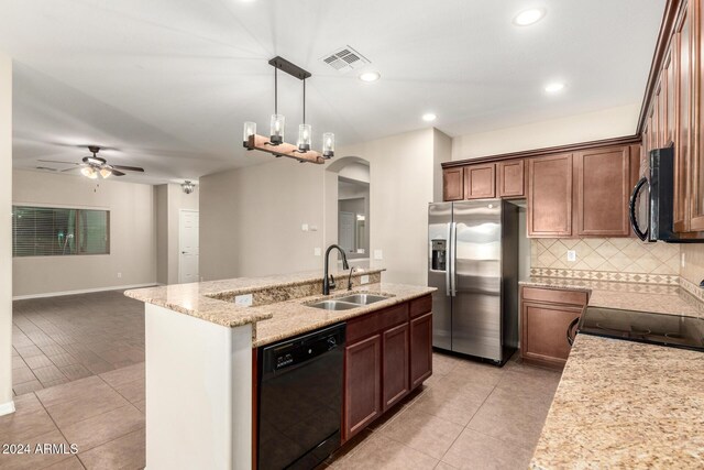 kitchen featuring ceiling fan, sink, an island with sink, pendant lighting, and black appliances