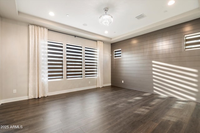 unfurnished room with wooden walls, baseboards, visible vents, dark wood-style floors, and recessed lighting