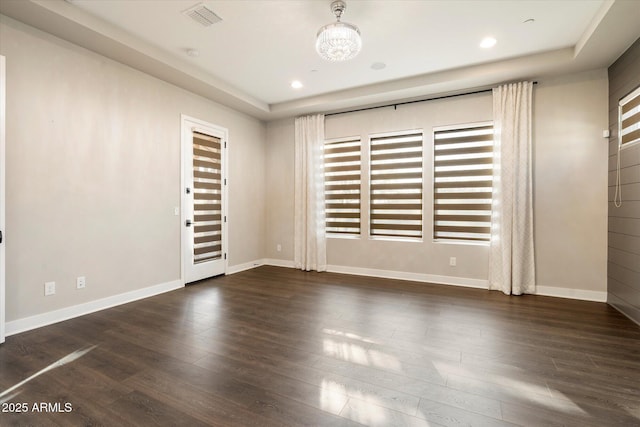 unfurnished room with dark wood finished floors, recessed lighting, visible vents, an inviting chandelier, and baseboards