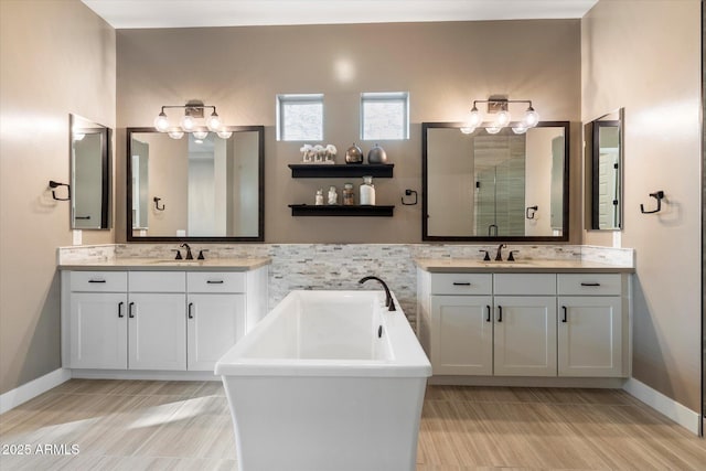 bathroom with a freestanding tub, two vanities, a sink, and a shower stall