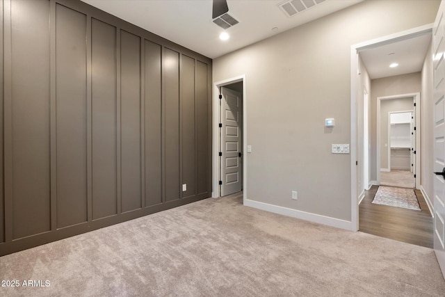 unfurnished bedroom featuring light colored carpet, visible vents, and baseboards