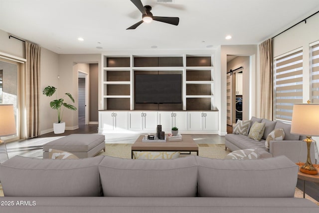 living area featuring ceiling fan, a barn door, recessed lighting, baseboards, and built in features