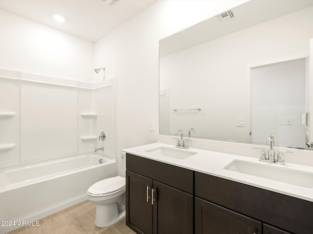 full bathroom featuring washtub / shower combination, wood-type flooring, vanity, and toilet