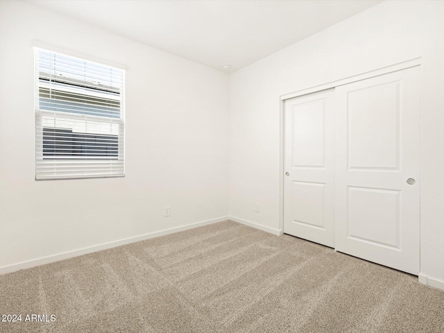 unfurnished bedroom with carpet and a closet