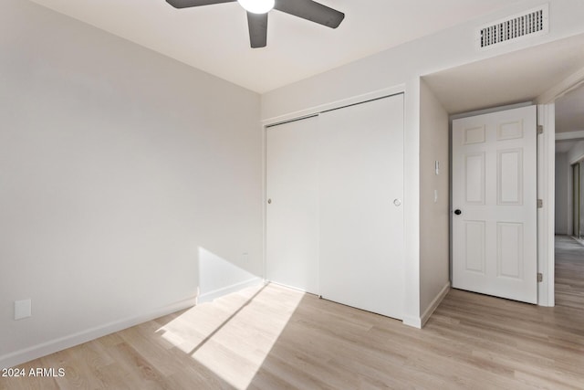 unfurnished bedroom with light hardwood / wood-style flooring, a closet, and ceiling fan