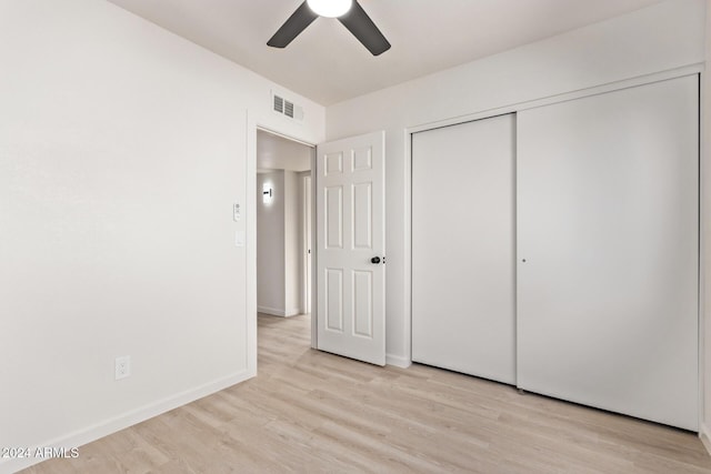 unfurnished bedroom featuring ceiling fan, light wood-type flooring, and a closet