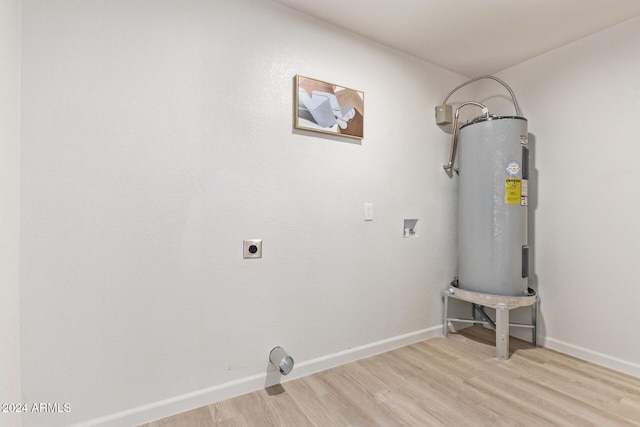 washroom featuring washer hookup, electric water heater, light hardwood / wood-style flooring, and hookup for an electric dryer