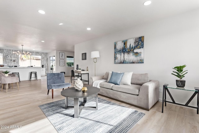 living room with a chandelier and light hardwood / wood-style flooring