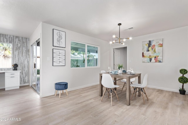 dining area featuring an inviting chandelier and light hardwood / wood-style floors