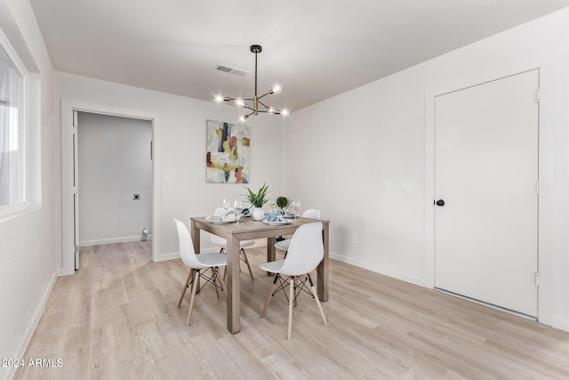 dining space featuring light hardwood / wood-style flooring and a notable chandelier