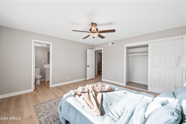 bedroom featuring ceiling fan, a closet, ensuite bath, and light hardwood / wood-style flooring