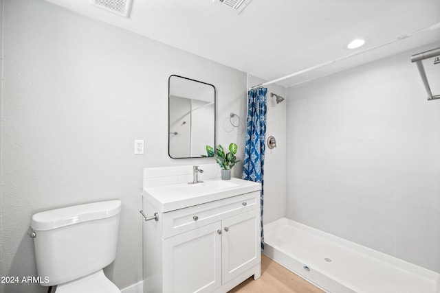 bathroom featuring toilet, hardwood / wood-style floors, vanity, and a shower with shower curtain