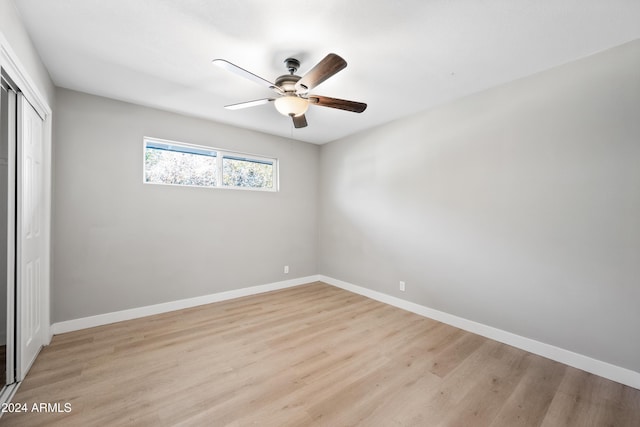 unfurnished bedroom featuring ceiling fan, light wood-type flooring, and a closet