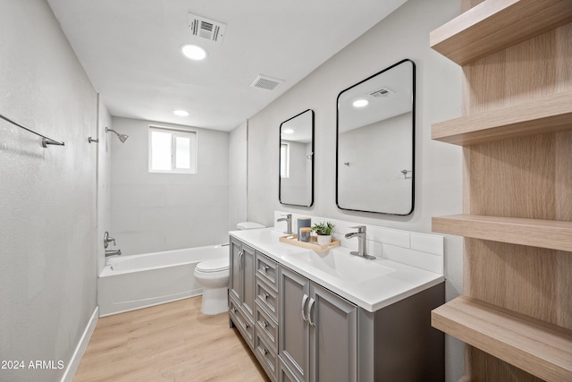 full bathroom with vanity, wood-type flooring, tiled shower / bath combo, and toilet