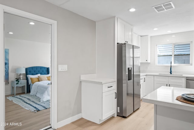 kitchen featuring light hardwood / wood-style floors, white cabinetry, and stainless steel appliances