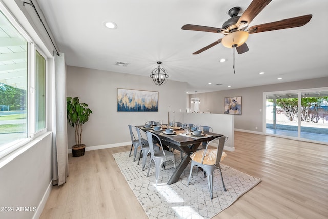 dining room featuring ceiling fan with notable chandelier and light wood-type flooring