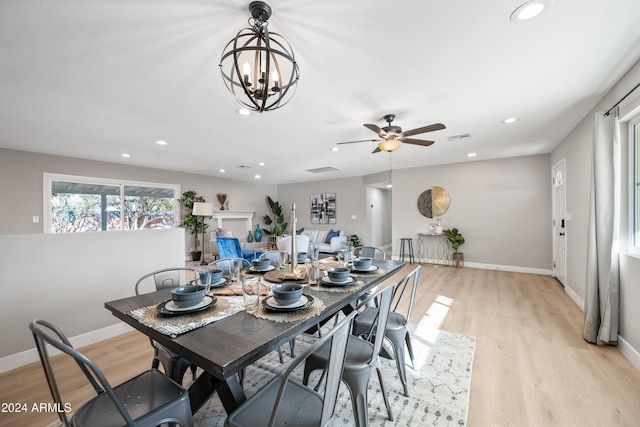 dining area featuring ceiling fan with notable chandelier and light hardwood / wood-style floors